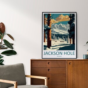 May include: A vintage-style poster featuring a snowy mountain scene with the text "JACKSON HOLE WYOMING". The poster is framed in black and uses a blue, green, and brown colour scheme.