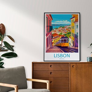 May include: A vintage travel poster featuring a yellow tram traveling up a hill in Lisbon, Portugal. The poster has a blue sky with white clouds and a view of the city in the background. The text "LISBON, PORTUGAL" is printed at the bottom of the poster.
