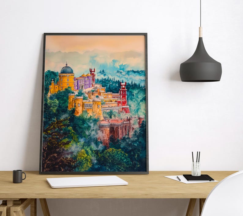 May include: A framed watercolor print of a colorful castle atop a lush, green hillside. The castle features a yellow dome, purple walls, and red towers. The artwork is set against a backdrop of blue and orange hues.