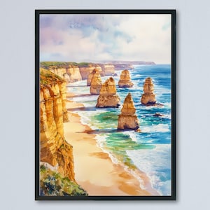 以下が含まれることがあります： 海食柱と崖のある海岸風景の水彩画。このアートワークは、青、黄、緑の色合いで海、ビーチ、岩の形成を描いています。額入りのプリントは白い壁に飾られています。