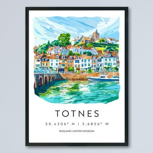Puede incluir: Impresión en acuarela enmarcada en negro de Totnes, Inglaterra. La obra representa una colorida escena frente al mar con edificios, un puente y un barco en el agua. El nombre de la ciudad y las coordenadas están impresos debajo.