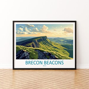 May include: A framed print of the Brecon Beacons in Wales. The artwork shows a green mountain with a stone path, under a blue sky with clouds. The text "BRECON BEACONS WALES" is at the bottom. The print is in a black frame.