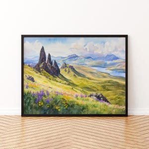 Könnte beinhalten: Ein gerahmtes Aquarellgemälde einer malerischen Landschaft. Das Kunstwerk zeigt eine Bergkette mit zerklüfteten Felsformationen, sanften grünen Hügeln und einem Gewässer unter einem blauen Himmel mit flauschigen Wolken. Lila und gelbe Wildblumen säumen den Vordergrund.