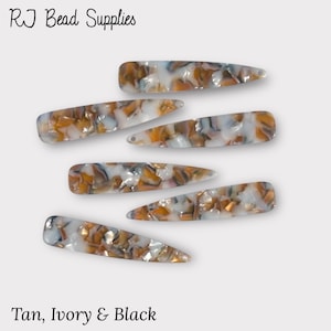 May include: Six tortoiseshell hair clips with a tan, ivory and black marbled pattern. RJ Bead Supplies.