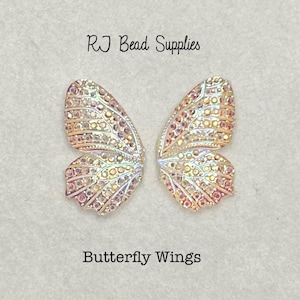 May include: Two iridescent butterfly wing charms with a gold and pink colour scheme. The wings are detailed with a textured pattern and are perfect for jewellery making or crafting projects. RJ Bead Supplies Butterfly Wings.