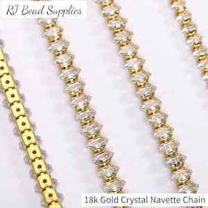 May include: Close-up of several strands of 18k gold crystal navette chain. The chains feature clear, sparkling crystal navette stones set in gold-coloured metal. The text "RJ Bead Supplies" is in the upper left corner.