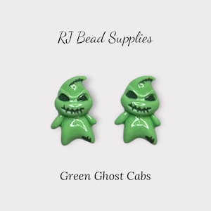 Peut inclure: Deux cabochons fantômes verts avec des traits noirs et une bouche en dents de scie. Les cabochons ont la forme d'un personnage d'un film d'animation populaire. Le texte "RJ Bead Supplies" et "Green Ghost Cabs" sont également visibles.