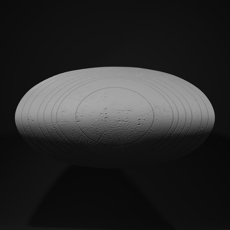 May include: A gray, oval-shaped object with concentric circular grooves and a textured surface. The object is set against a dark background, creating a sense of depth and highlighting its form. The design suggests a unique decorative piece.
