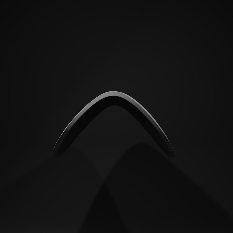 May include: A glossy black boomerang, curved and aerodynamic, against a dark background. The boomerang's smooth surface reflects light, highlighting its shape. This traditional toy is designed for throwing and returning.