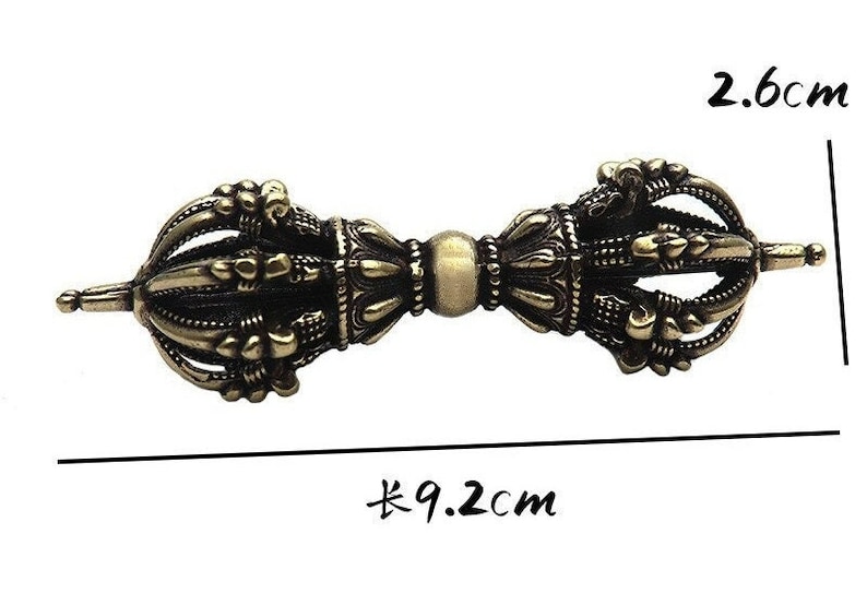 May include: A gold-colored metal prayer wheel with intricate details. The wheel is 9.2 inches long and 2.6 inches wide.
