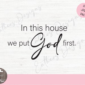 May include: A white background with a pink stripe at the bottom. The text "In this house we put God first." is written in black cursive font.