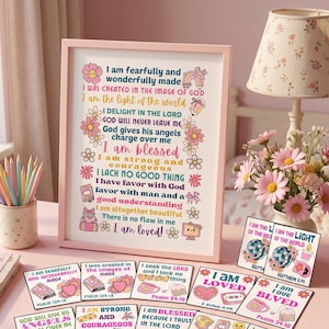 May include: A framed print featuring inspirational text in pink, blue, and yellow, surrounded by floral and whimsical icons. Accompanying the print are several smaller square cards with similar religious affirmations, colourful graphics, and scripture citations.