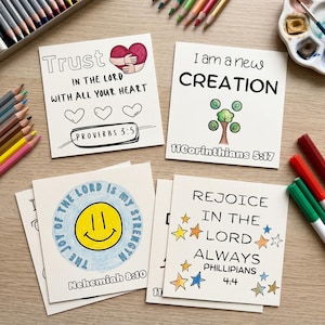 May include: Four square white cards featuring hand-drawn illustrations and text. One card says Trust in the Lord with all your heart Proverbs 3:5, another I am a new creation 11 Corinthians 5:17, another The joy of the Lord is my strength Nehemiah 8:10, and the last Rejoice in the Lord always Philippians 4:4.