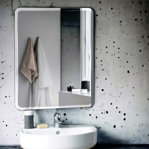 May include: A white bathroom sink with a chrome tap and a white rectangular mirror with a silver frame. The mirror is hanging on a grey wall with black splatter paint.