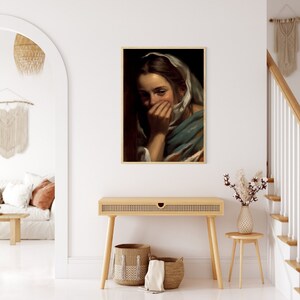May include: A painting of a woman with a white headscarf covering her hair and part of her face. She is wearing a blue and brown dress and has a sad expression on her face.