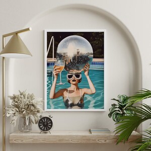 May include: A woman in a silver swimsuit and sunglasses holds a disco ball above her head while floating in a pool.