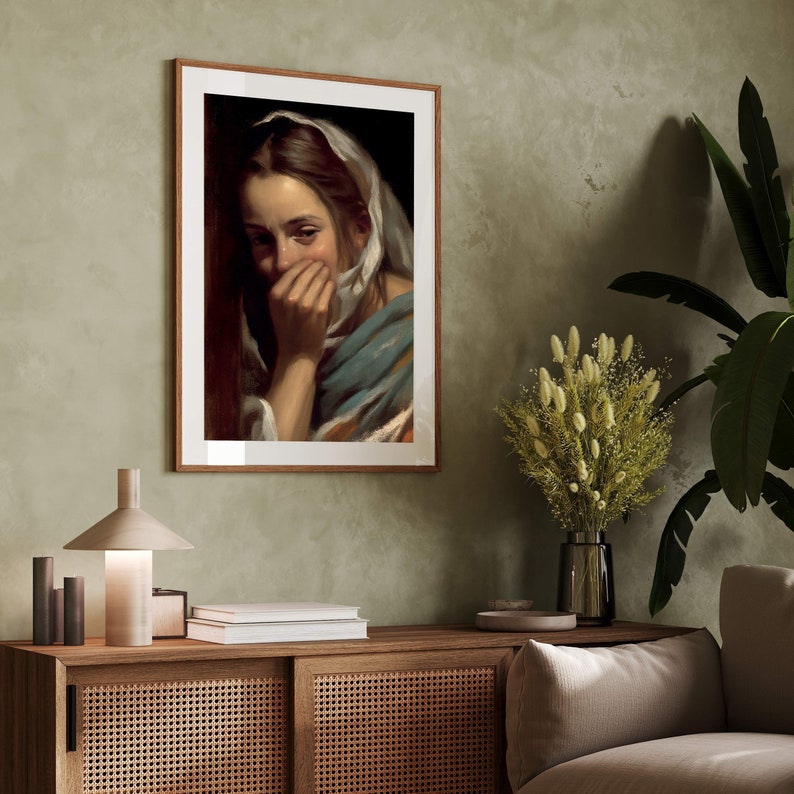 May include: A framed painting of a woman with a white headscarf, looking down and covering her mouth with her hand. The painting is set against a brown background.