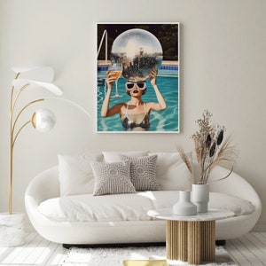 May include: A woman wearing sunglasses holds a disco ball above her head while floating in a swimming pool. The pool is surrounded by a wooden deck and lush greenery.
