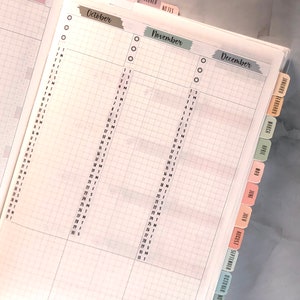 May include: A monthly planner with tabs for each month of the year, September through December. The tabs are color-coded and have the month name written on them.