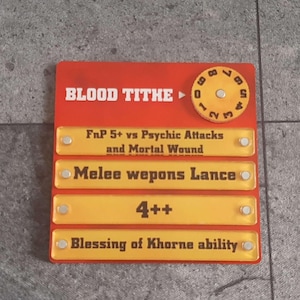 May include: A rectangular game card with a red background and yellow text and details. The card reads "BLOOD TITHE" at the top, with a circular dial. Below are details about attacks and abilities, including "FnP 5+" and "Melee wepons Lance."