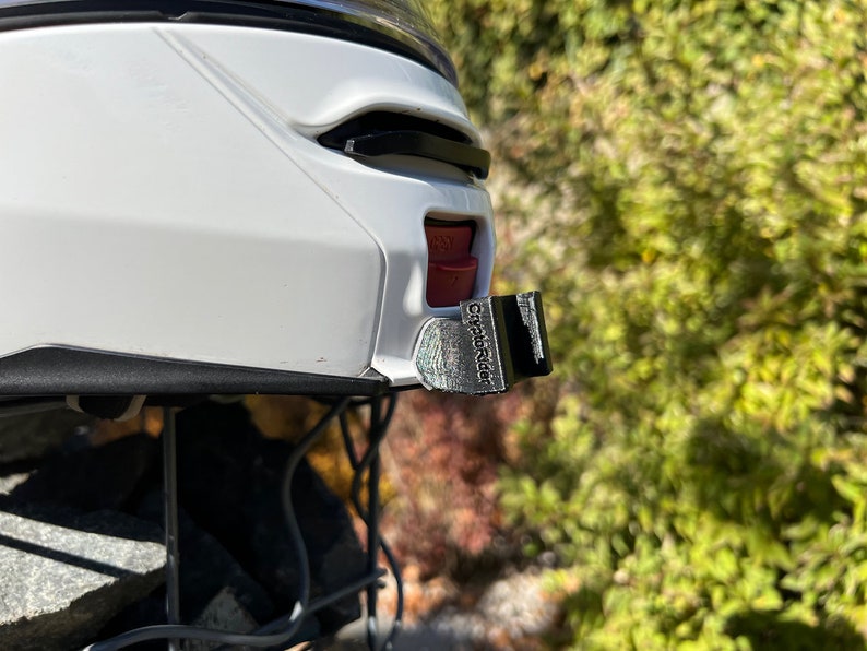 May include: A white helmet with a black and silver CityPluRider camera mount attached to the side.