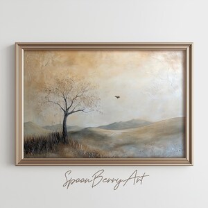 May include: A framed painting depicting a landscape with a solitary tree in the foreground and a bird in flight above. The sky is a pale yellow and the hills are a muted green and brown. The painting has a textured surface and a gold frame.