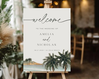 May include: A welcome sign for a wedding, displayed on a wooden easel. The sign features the word "welcome" in elegant script, followed by the names Amelia and Nicholas, and the date and location: 08.21.2028 | LA JOLLA BEACH. The bottom of the sign has a watercolor illustration of palm trees and a beach.