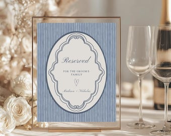 May include: A framed wedding sign with the word "Reserved" in elegant script. The sign features a blue and white striped background and an oval design with the names "Madison + Nicholas".