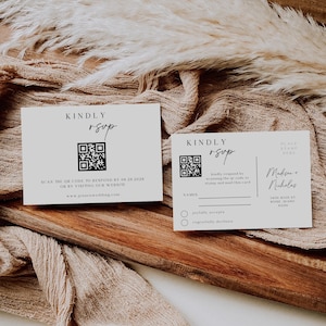 May include: A white RSVP card with a black QR code and the text "KINDLY RSVP". The card also includes instructions to scan the QR code or visit the website www.jensenwedding.com. The card is on a brown surface.