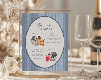 May include: A framed sign with the words "Signature Drinks" in elegant script. The sign features a blue and white striped background and includes drink names like "The Bruno" and "The Poppy", each with a picture of a dog and a cocktail.