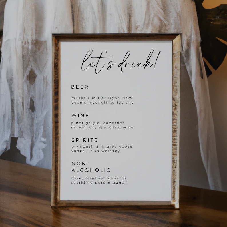 May include: A framed sign with the text "let's drink!" and a list of alcoholic and non-alcoholic beverages. The list includes beer, wine, spirits, and non-alcoholic options.