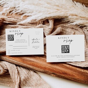 Op de afbeelding: Twee witte RSVP-kaarten met een zwart-witte QR-code, de tekst "KINDLY RSVP" en de tekst "SCAN THE QR CODE TO RESPOND BY 08.28.2028 OR BY VISITING OUR WEBSITE www.jenkenwedding.com".