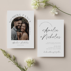 May include: A wedding invitation with a photo of a couple in a white arch. The text reads "Nothing Fancy, Just Love" and "Amelia + Nicholas, 08.28.2028". The invitation also includes the couple's names, wedding date, time, location, and the phrase "drinks and dancing to follow".