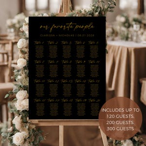 May include: Black wedding seating chart with gold lettering. The chart lists tables 1 through 20 with guest names. The text at the top reads "our favorite people" and "Clarissa + Nicholas | 06.21.2028". The bottom of the chart reads "Includes up to 120 guests, 200 guests, 300 guests".