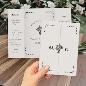 Op de afbeelding: Huwelijksuitnodiging met een zwart-wit bloemenontwerp. De uitnodiging bevat details zoals de datum, tijd, locatie, accommodatie en kledingvoorschriften. De RSVP-kaart bevat een ruimte voor gasten om hun antwoord te geven.