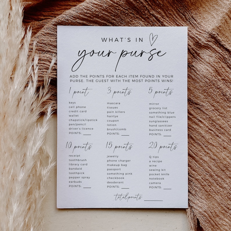 K&ouml;nnte beinhalten: Eine wei&szlig;e Karte mit dem Text "What's in your purse?" in schwarzer Kursivschrift. Die Karte ist ein Spiel, bei dem die G&auml;ste Punkte f&uuml;r Gegenst&auml;nde sammeln, die sie in ihren Handtaschen finden. Die Gegenst&auml;nde sind in Kategorien mit Punktwerten aufgelistet: 1 Punkt, 3 Punkte, 5 Punkte, 10 Punkte, 15 Punkte und 20 Punkte.