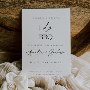 May include: A white invitation card with black text announcing an "I do BBQ" engagement party for Amelia and Graham on July 28th, 20XX at 6:30 PM. The card includes the address and RSVP information.