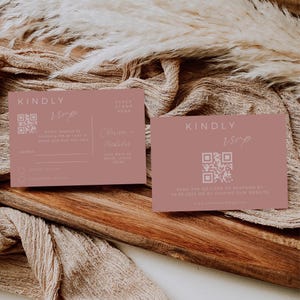 May include: A pink RSVP card with a QR code and the text "KINDLY RSVP". The card also includes the names "Clarisse - Nicholas" and their address. The text "PLACE STAMP HERE" is at the top of the card.