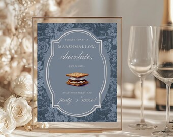 May include: A framed sign with a blue floral background and gold trim. The sign reads "PLEASE TOAST A MARSHMALLOW, chocolate, AND MORE... BUILD YOUR TREAT AND party s'more!" A graphic of a s'more is in the center.