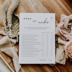 May include: A printable wedding game with the title "over or under" and a list of 15 questions about the bride and groom. Players guess whether the answer to each question is over, under, or just right. The game includes a scorecard at the bottom.