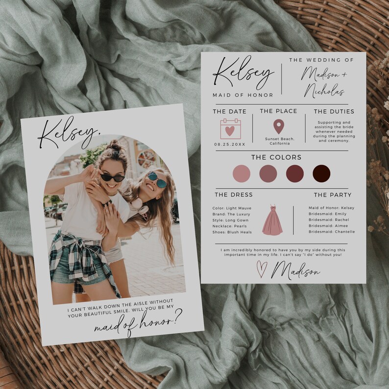 May include: A card with a photo of two women smiling at the camera. The card says "Kelsey. I can't walk down the aisle without your beautiful smile. Will you be my maid of honor?" The card also includes details about a wedding, including the date, location, and color scheme.