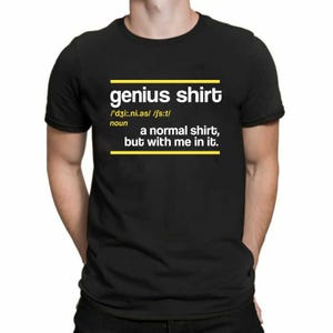 May include: Black t-shirt with the text "genius shirt" in white, with a yellow horizontal line above and below the text. The definition of "genius shirt" is also printed on the shirt.