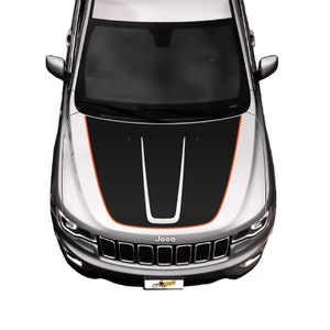 May include: A silver Jeep with a black and orange hood decal. The decal has two black stripes with a white stripe in the center. The Jeep has a black grille with the word "Jeep" in white letters.