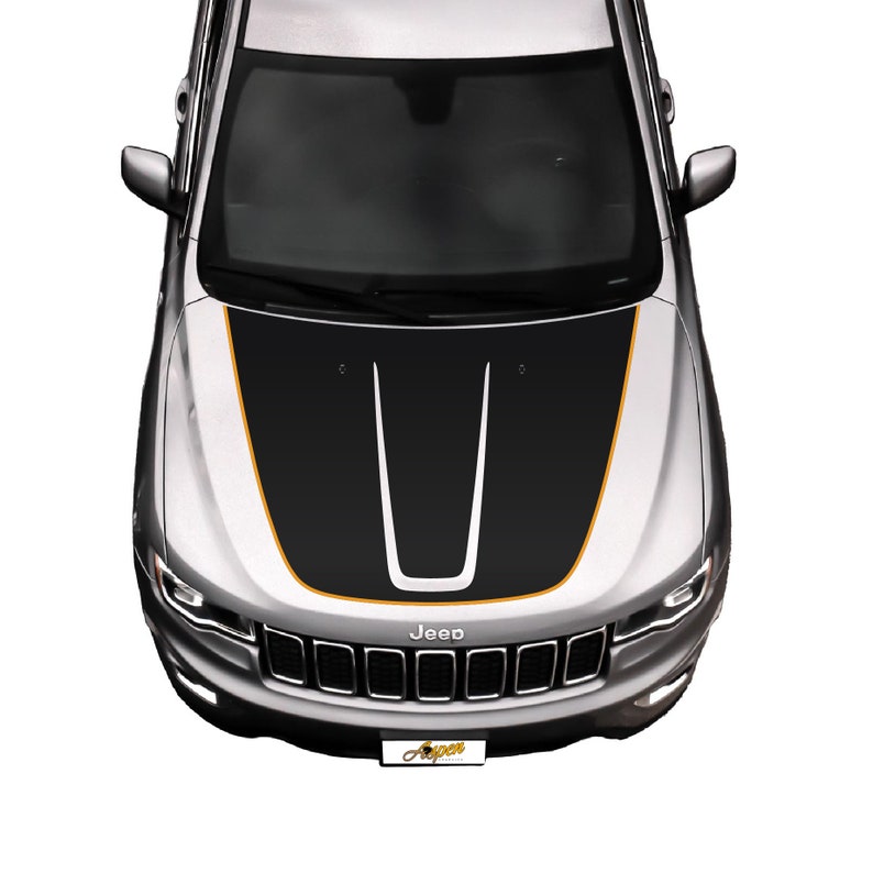 May include: A silver Jeep with a black and orange hood decal. The decal has two black stripes with a white stripe in the center. The Jeep has a black grille with the word "Jeep" in white letters.