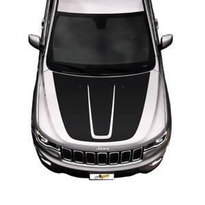 May include: A silver Jeep with a black hood decal featuring two black stripes with a white stripe in the center. The Jeep has a black grille with the word "Jeep" in white letters.