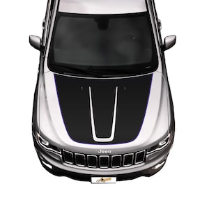 May include: A silver Jeep with a black and white hood decal. The decal has a blue outline and a Jeep logo on the front grille.