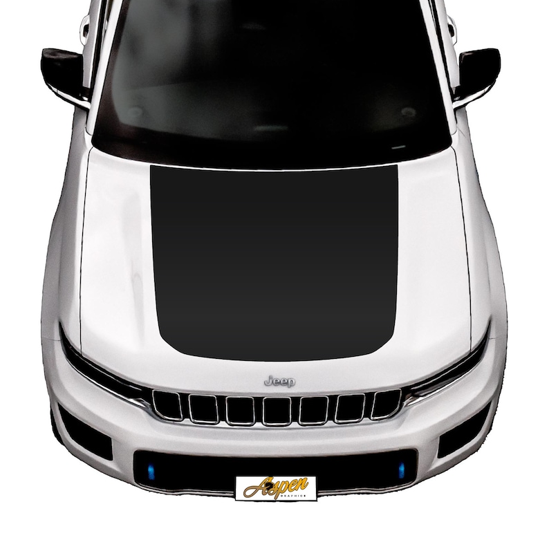 May include: A white Jeep with a black hood wrap. The Jeep has a black grille with the word "Jeep" in silver lettering. The front bumper has two blue lights.