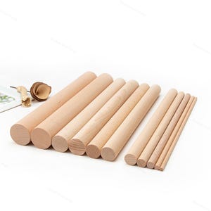 May include: A collection of wooden rolling pins and dowels of varying sizes. The rolling pins are cylindrical and made of light-colored wood. The dowels are also made of light-colored wood and are of different diameters.