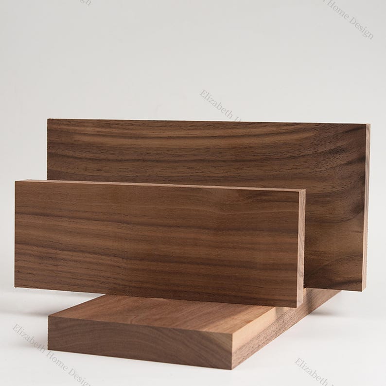 May include: Three pieces of walnut wood, stacked on top of each other. The wood has a rich brown color and a natural grain pattern.