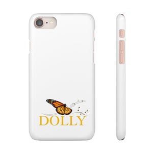 May include: A white smartphone case featuring a monarch butterfly graphic with trailing musical notes and the word DOLLY in gold lettering. The case is shown from the back and side, displaying a camera lens cutout and metallic side buttons.